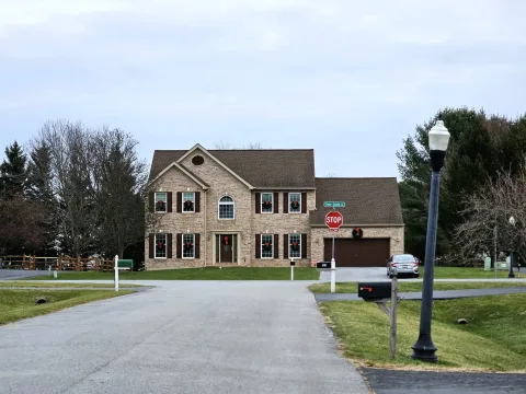A two-story brick-front home at the end of a neighborhood street