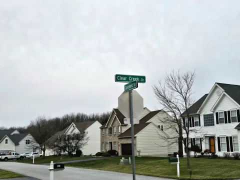 A Clear Creek Drive street sign at a corner lined with two-story homes